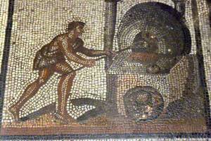A detailed Roman mosaic depicting a baker using a long wooden peel to place bread inside a wood-fired oven